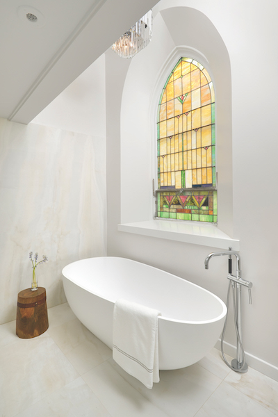 White bath tub and stained glass window