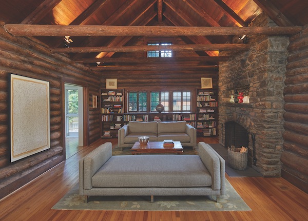 Living room with sofa and fireplace in log cabin open frame