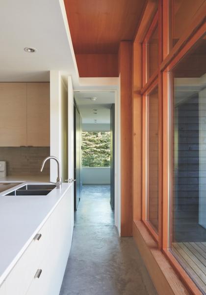 Kitchen in minimalist style custom home with dark gray hallway floors