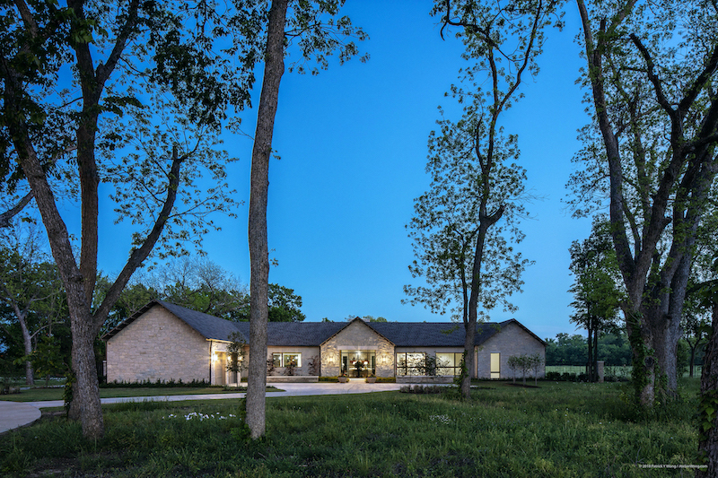 Twilight view of Texas custom home stone exterior with breezeway in the middle