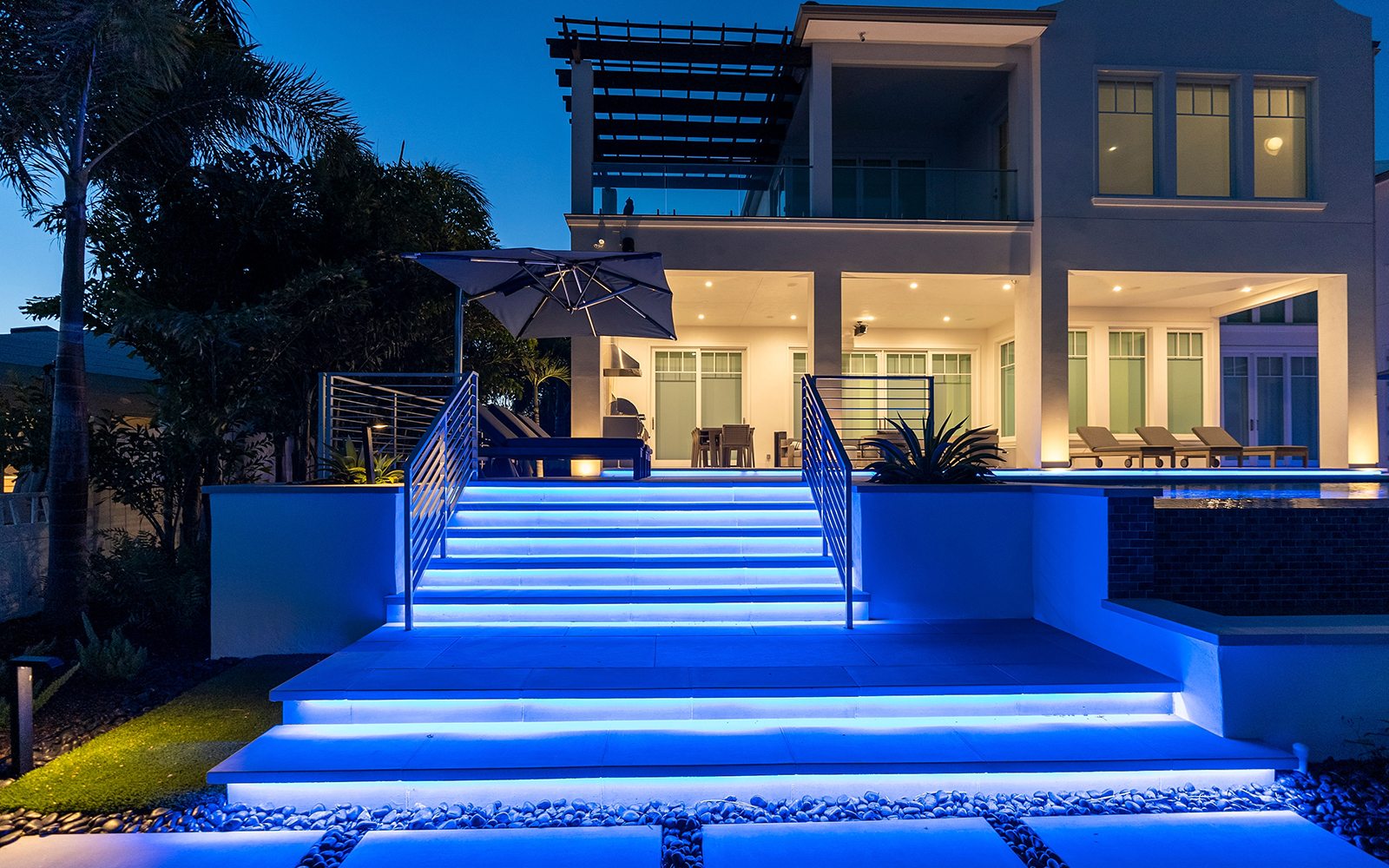 Lighted stairs leading to the outdoor living space of luxury contemporary home