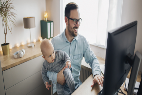 Man at home office desk holding child