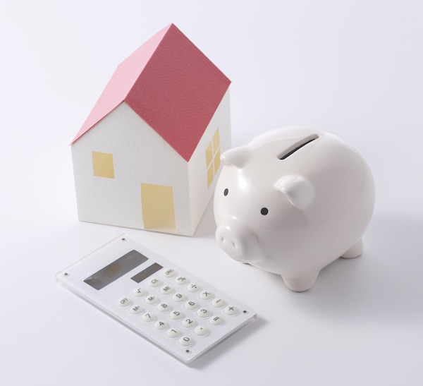 Calculator and piggy bank with a model of a house